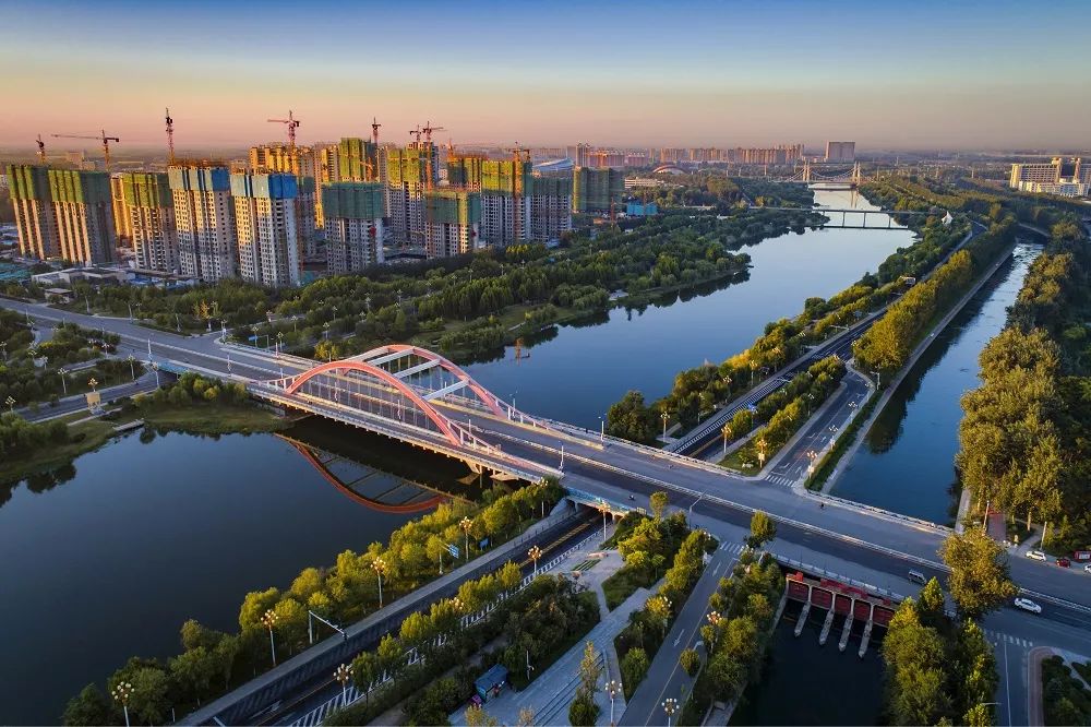陈口路两旁成片的小区正在修建中,不远处的二干渠公园穿城而过.