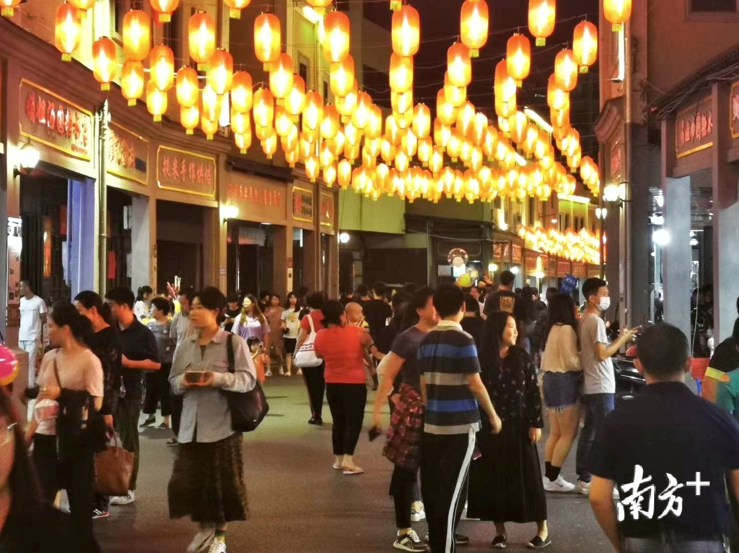 市民和游客漫步于老街,欣赏夜景,品赏美食.